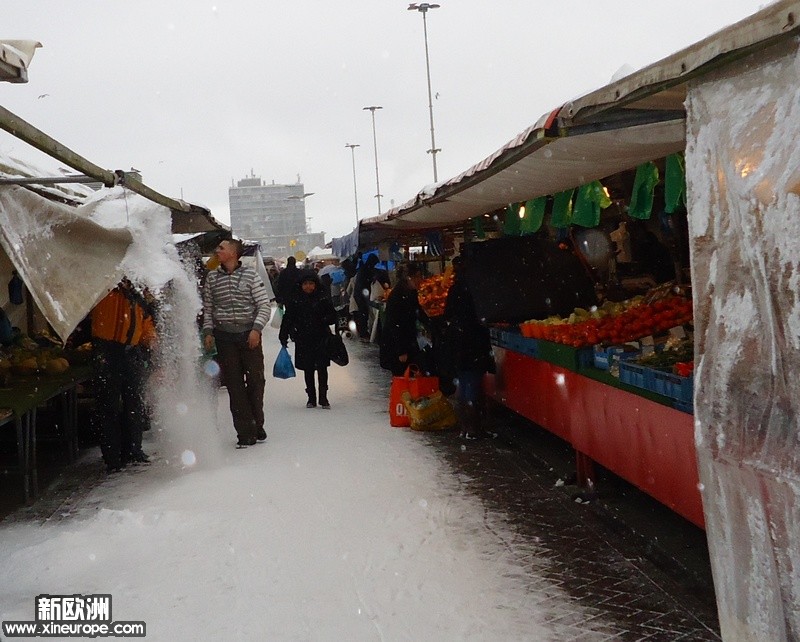 商贩清理积雪，担心把小棚子压塌。呵呵。.jpg