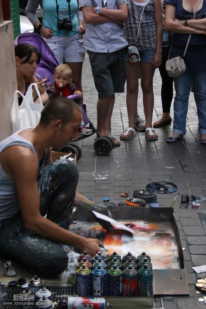 街头喷画艺人，左边正在吸烟的是他的女人及孩子。.jpg