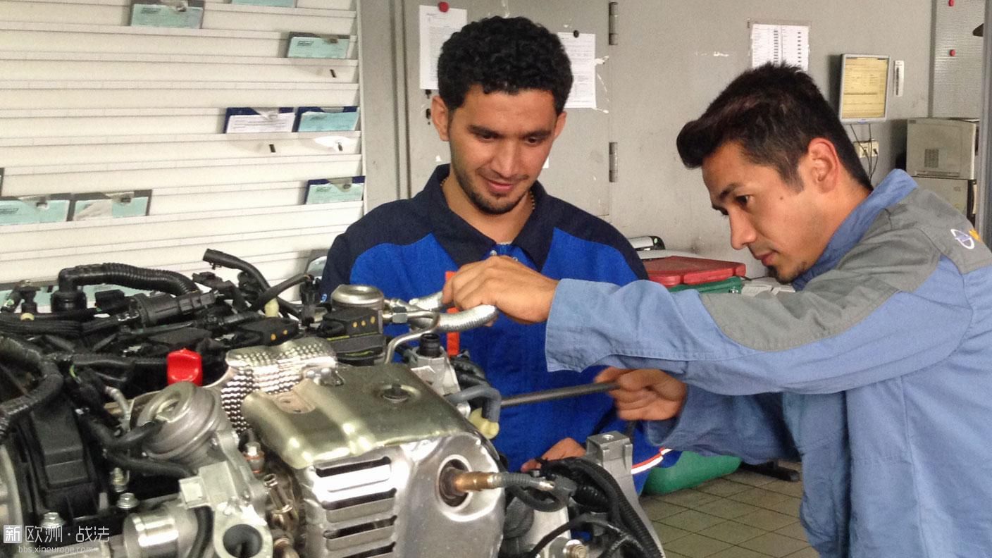 Zwei afghanische Lehrlinge arbeiten an einem Automotor.jpg